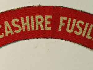 LANCASHIRE FUSILIERS WW2 Printed Cloth Shoulder Title Badge - CALICO PRINTERS ---  Lot No. 6297