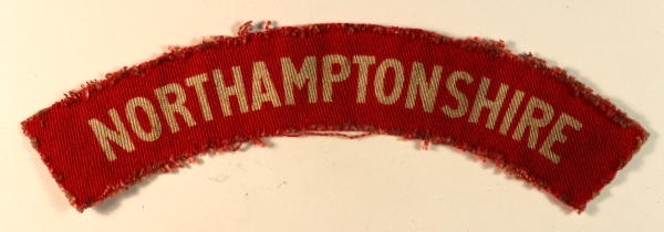 NORTHAMPTONSHIRE WW2 Printed Shoulder Title Badge – CALICO PRINTERS — Lot No. 6897