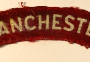 MANCHESTER Regiment WW2 Printed Shoulder Title Badge - CALICO PRINTERS ---  Lot No. 6990